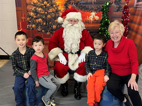 Three children and a grandmother visiting with Santa